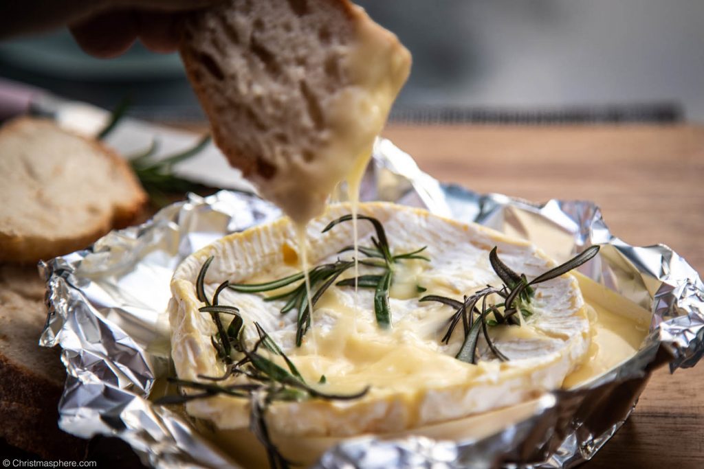 Dipping bread into baked camembert