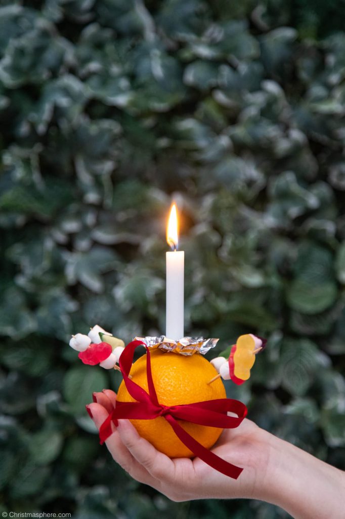 holding a candle in orange christingle
