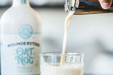 hand pouring a glass of eggnog