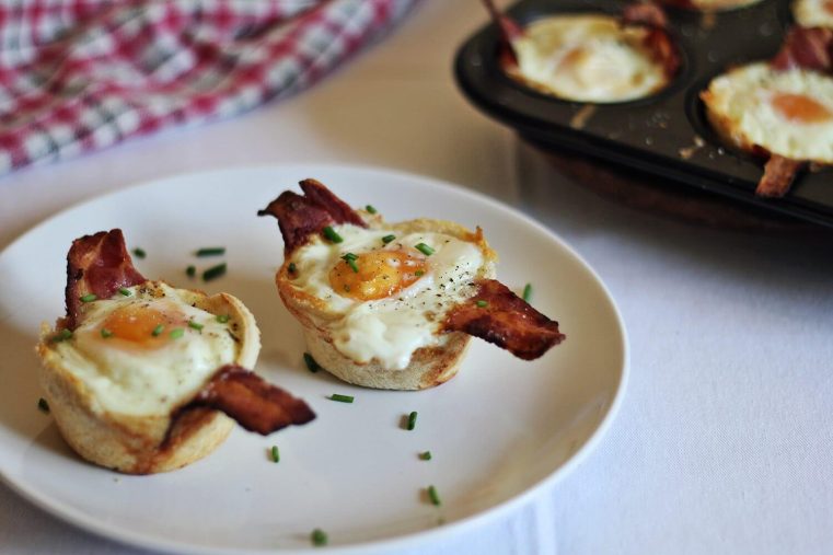 Plate of toast, bacon, egg cups