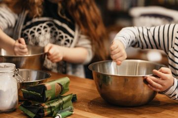 Hands of children stirring in mixing bowls